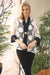 Woman wearing a white polka dots patterned jacket with one-button closure and 3/4 sleeves from Joseph Ribkoff