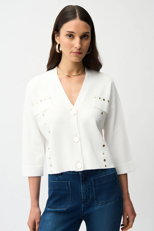 Woman wearing a white cropped v-neck cardigan with mirrored grommet accents from Joseph Ribkoff