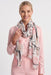 Woman wearing a white scarf with multicolor abstract pattern and fringe edges from Joseph Ribkoff