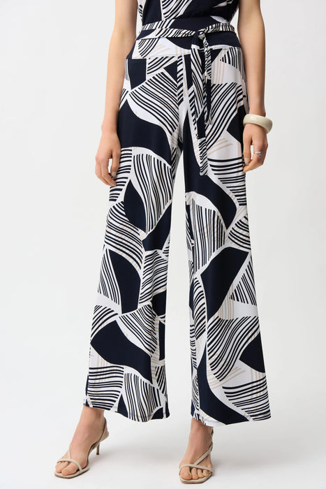 Woman wearing a geometric patterned wide leg pants with high elastic waistband  and self-tie belt from Joseph Ribkoff