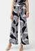 Woman wearing a geometric patterned wide leg pants with high elastic waistband  and self-tie belt from Joseph Ribkoff