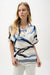 Woman wearing an abstract-patterned boxy top with collared v-neck and short sleeves from Joseph Ribkoff