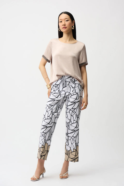 Woman wearing a white relaxed straight pants with black abstract pattern, pull on waistband and ankle length from Joseph Ribkoff