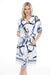 Woman wearing a white printed knee-length dress with abstract and stripes pattern from Joseph Ribkoff