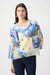 Woman wearing a colorful semi-sheer boxy top with cowl neck and tropical print from Joseph Ribkoff