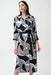 Woman wearing Joseph Ribkoff geometric print shirt sash dress with belt, button-down front, and midi length, offering a modern and polished silhouette.