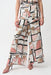 Woman wearing a geometric-patterned wide leg pants with waist sash from Joseph Ribkoff