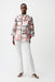 Woman wearing a lightweight organza abstract print boxy jacket with zip front and three-quarter sleeves, paired with white pants and heels.