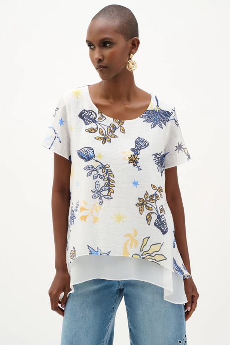 Woman wearing Joseph Ribkoff vanilla multi tropical print trapeze tunic with short sleeves, a flowy asymmetrical hem, and a relaxed lightweight fit for summer styling.