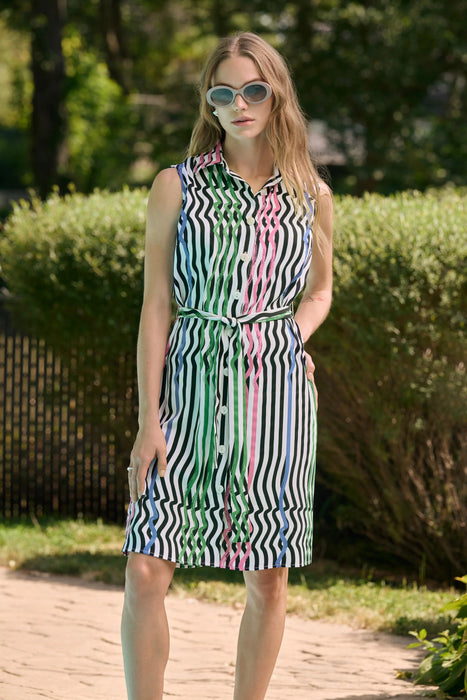 Woman wearing vanilla multi stripe print sleeveless shirt dress with waist sash and button front design, styled for a chic summer outdoor look