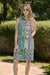 Woman wearing vanilla multi stripe print sleeveless shirt dress with waist sash and button front design, styled for a chic summer outdoor look