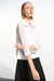 Woman wearing a white open knit sweater top with zip front and 3/4 sleeves from Joseph Ribkoff