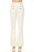 Woman wearing a white flared pants with sailor buttons accent at the front from Joseph Ribkoff