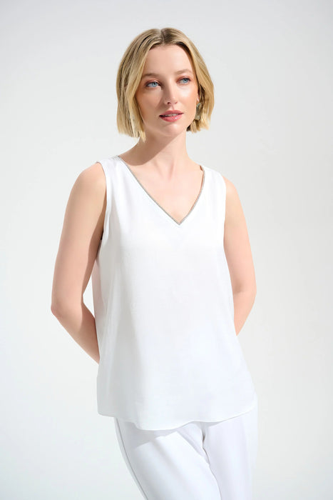 Woman wearing a white sleeveless top with rhinestone trim v-neck from Joseph Ribkoff