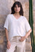 Woman wearing a white v-neck sweater top with short dolman sleeves from Joseph Ribkoff