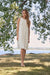 Woman wearing Joseph Ribkoff sleeveless A-line knit dress for elegant daytime outfit