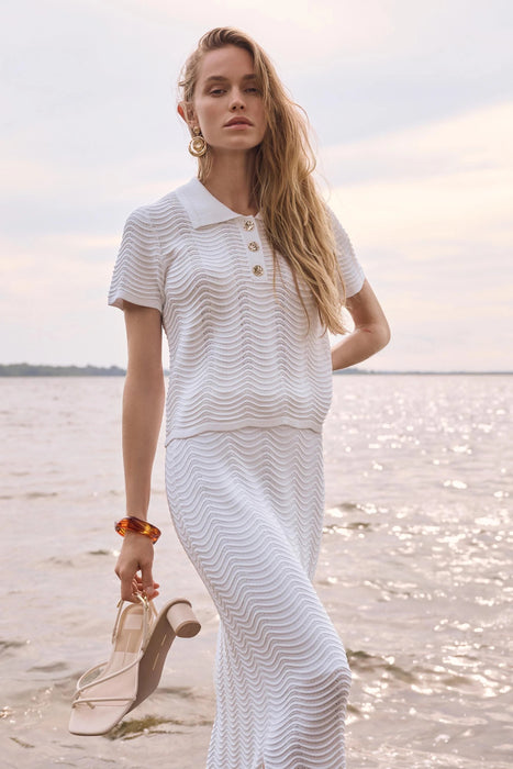 Woman wearing Joseph Ribkoff vanilla textured sweater knit short sleeve shirt, featuring a polo collar, button detail, soft knit fabric, and a relaxed elegant fit.