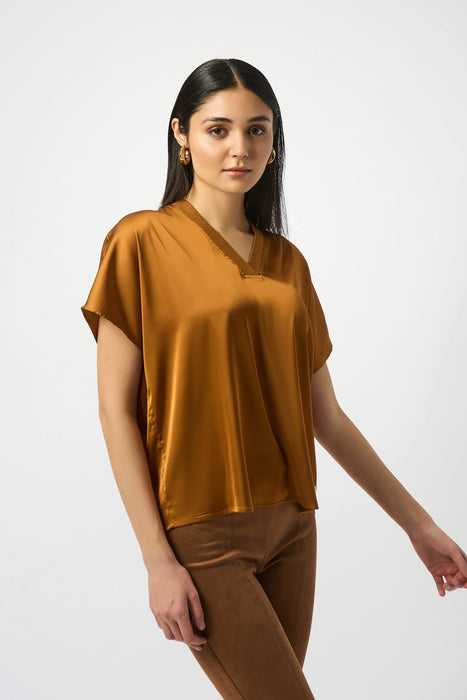 Woman wearing a brown satin top with v-neck and short sleeves