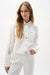 Woman wearing designer white lace denim jacket over outfit