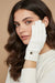 Woman wearing white knit gloves with rhinestone embellishments from Joseph Ribkoff