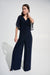 Woman wearing a wrap rhinestone trim wide leg jumpsuit featuring flutter sleeves and an elegant flowing silhouette