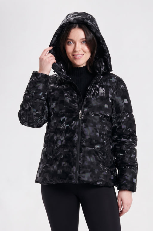 A woman wearing a black hooded puffer jacket with a digital camouflage pattern from Nikki Jones