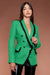 Woman wearing green textured blazer with black frayed trim and flap pockets from OO LA LA