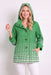 Woman wearing the Oopera Green Polka Dot Reversible Toggle Raincoat with a green and white ombre pattern, A-line silhouette, and long turn-back cuff sleeves.