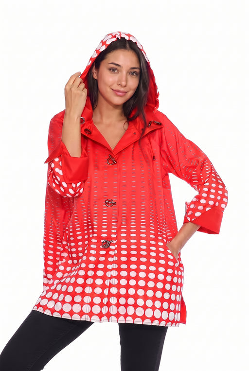 Woman wearing the Oopera red and white polka dot reversible toggle raincoat with an adjustable hood, relaxed fit, and water-repellent fabric.