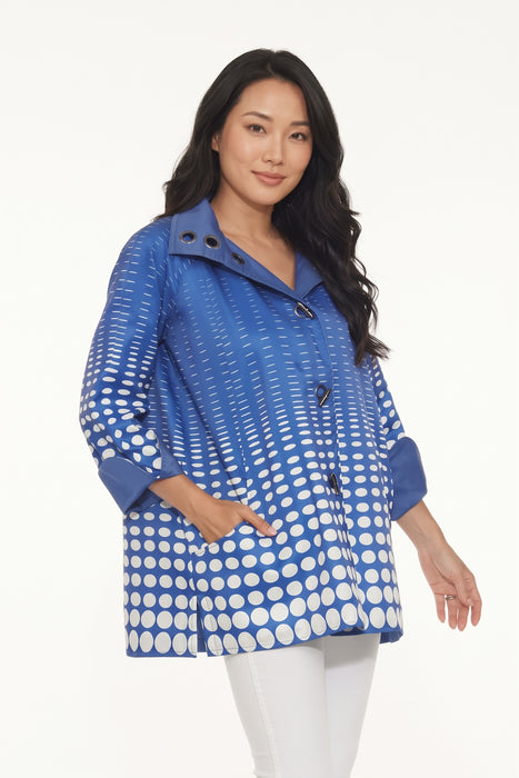 Woman wearing the Oopera Blue Polka Dot Reversible Toggle Raincoat with a cobalt blue and white ombre pattern, A-line swing silhouette, and roomy sleeves.