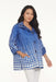 Woman wearing the Oopera Blue Polka Dot Reversible Toggle Raincoat with a cobalt blue and white ombre pattern, A-line swing silhouette, and roomy sleeves.