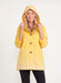 Woman wearing the Oopera Yellow Polka Dot Reversible Toggle Raincoat with a vibrant ombre pattern, adjustable hood, and lightweight water-repellent fabric.