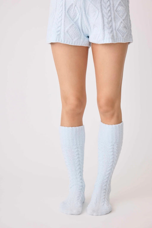 Woman wearing a light blue soft chenille cable knit knee length socks 