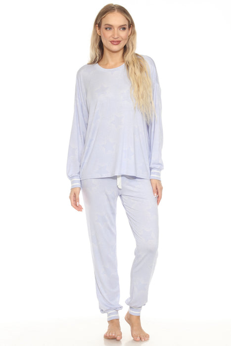 Woman wearing a blue matching loungewear top and pant with subtle stars pattern and striped rib cuffs