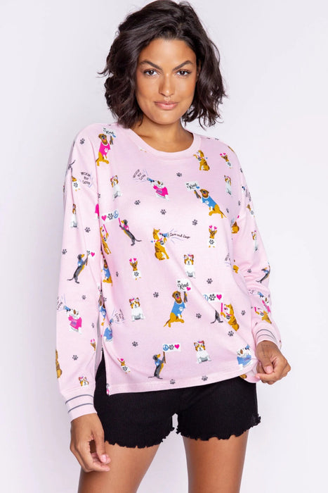 Woman wearing a pink pajama top with cute dog prints from PJ Salvage