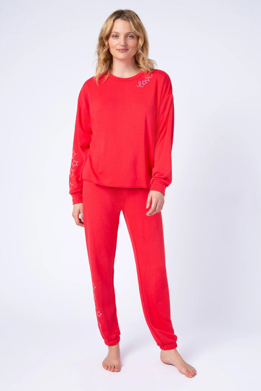 Woman wearing a red matching long sleeve top and jogger pant with star embroidery from PJ Salvage