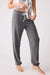 Person wearing gray fleece jogger lounge pant with drawstring waistband