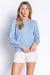 Woman wearing a light blue sweater knit lounge top with hearts pattern