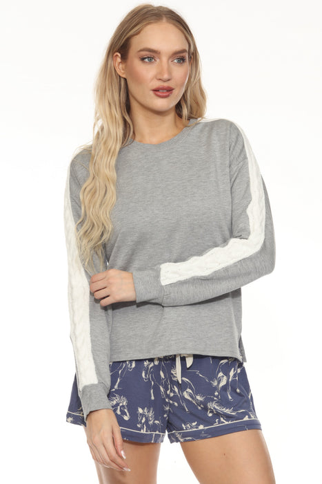 Woman wearing a gray pullover lounge top with cable knit insert at the sleeves