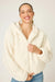 Woman wearing an ivory fuzzy hooded zip up jacket with long sleeves from PJ Salvage
