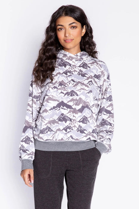 Woman wearing a patterned pullover hoodie with mountain range print