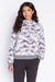 Woman wearing a patterned pullover hoodie with mountain range print