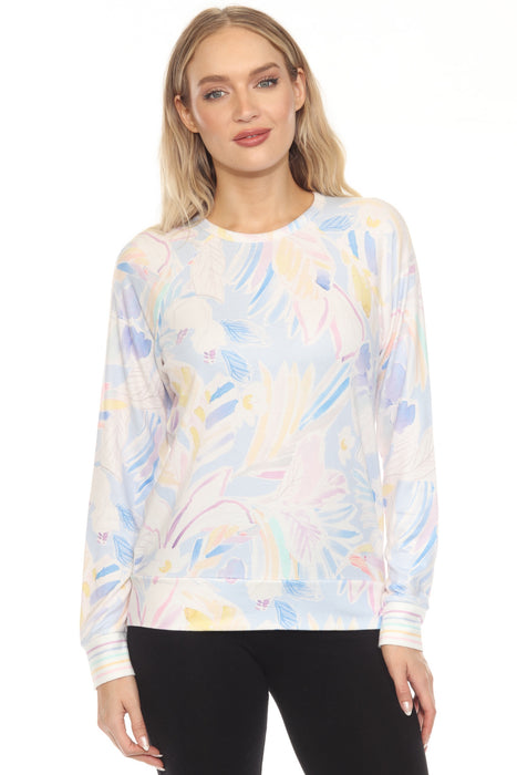 Woman wearing a lounge top with pained floral print in pastel hues and long sleeves