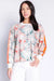 Woman wearing a long sleeve lounge pullover top with tropical leaf print and stripe on the sleeves