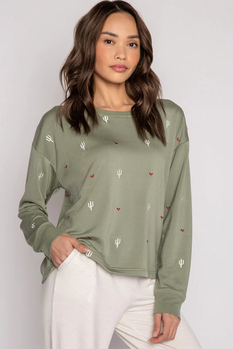 Woman wearing a green long sleeve sleepwear top with hearts and cactus embroideries from PJ Salvage