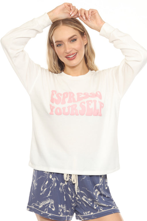 Woman wearing a white fleece pullover lounge top with "Espresso Yourself" pink graphic print at the front