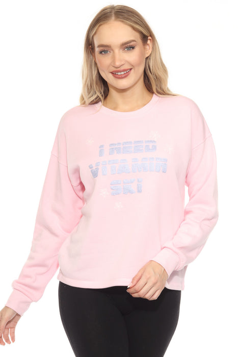 Woman wearing a pink sweatshirt with "I Need Vitamin Ski" text embroidery