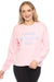 Woman wearing a pink sweatshirt with "I Need Vitamin Ski" text embroidery