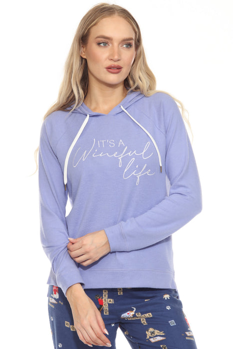 Woman wearing a purple hoodie with 'It's a wineful life' text graphic at the front and long raglan sleeves