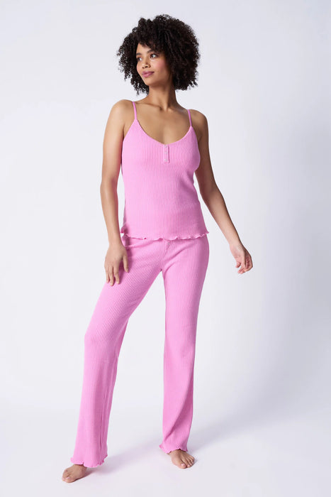 Woman wearing a pink matching pajama cami top and pant from PJ Salvage